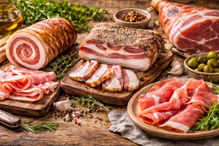 Панчетта, гуанчале і прошуто на дерев’яних дошках — традиційні італійські м’ясні делікатеси