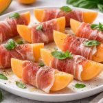 прошутто з динею без шкірки, нарізаною скибками та загорнутою у хамон