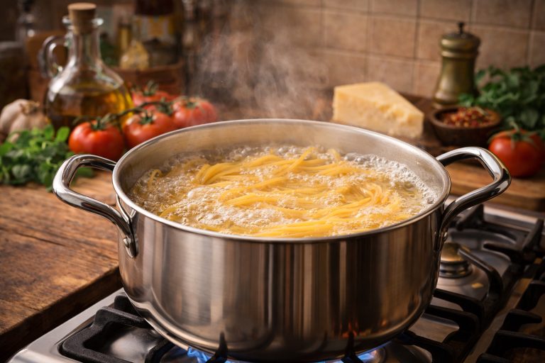 як правильно варити пасту — спагеті варяться у великій каструлі на кухні в італійському стилі
