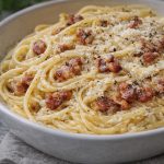 спагетті карбонара з гуанчале, сиром та чорним перцем у тарілці