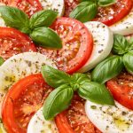 салат капрезе з томатами, моцарелою та базиліком на тарілці