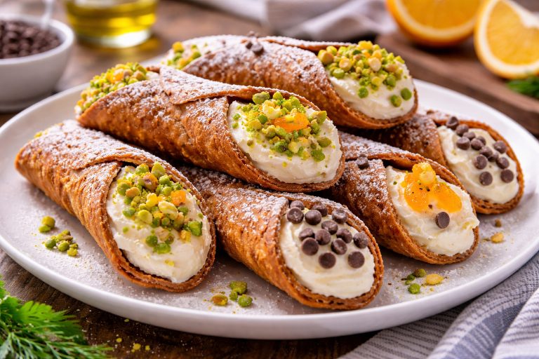 Каннолі (cannoli) з рікотою, фісташками, шоколадом і цукатами на тарілці